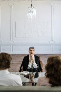 Therapist discussing relationship issues with couple in modern office setting. Professional consultation session indoors.