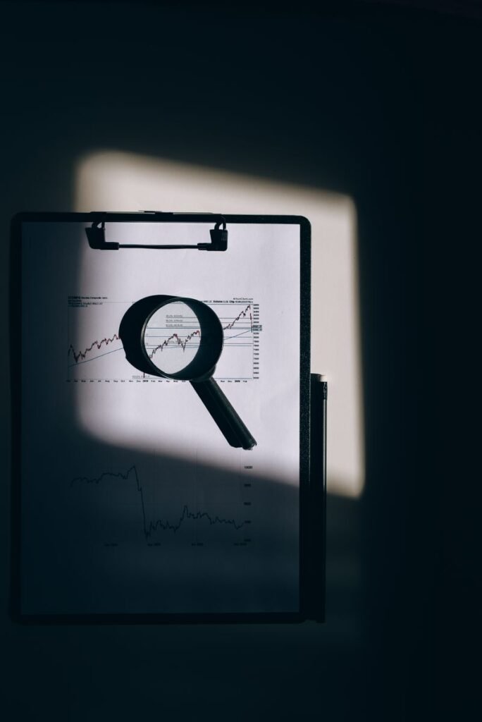 Magnifying glass over a document on a clipboard, representing property due diligence review in Pakistan