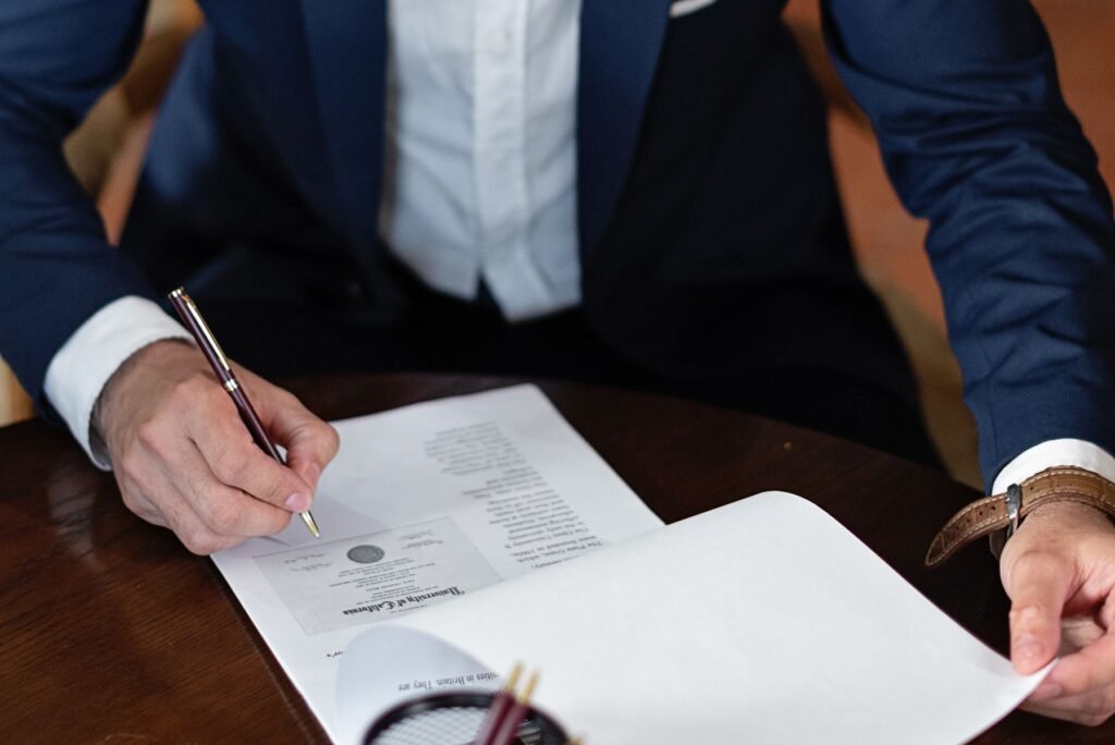 Man in a suit signing a legal document, representing legal documentation and contract execution in Pakistan