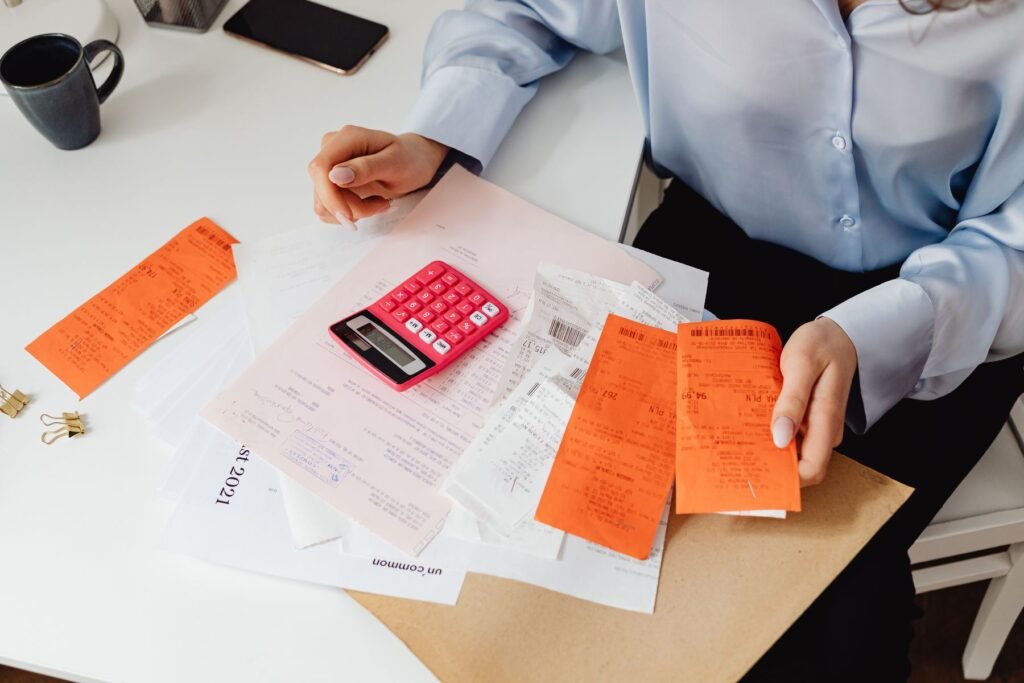 Person reviewing receipts with a calculator, representing tax compliance and filing in Pakistan